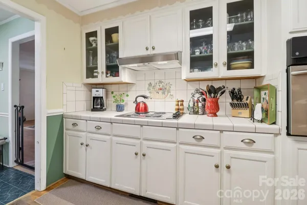 a kitchen with white cabinets and sink
