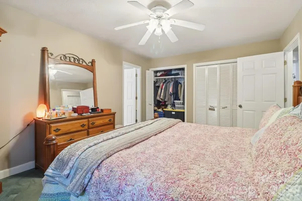 a bedroom with a bed and a mirror on the dresser