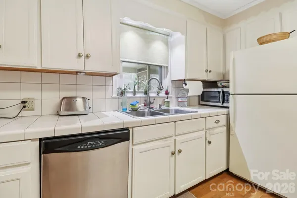 a kitchen with white cabinets and sink