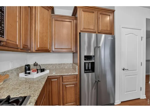 a kitchen with stainless steel appliances granite countertop a stove top oven a sink dishwasher and a dining table with cabinets