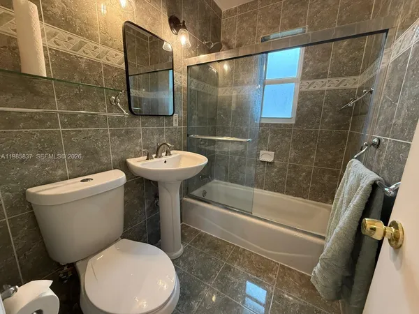 a bathroom with a sink mirror toilet and shower