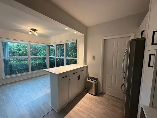 a view of a kitchen with wooden floor and electronic appliances