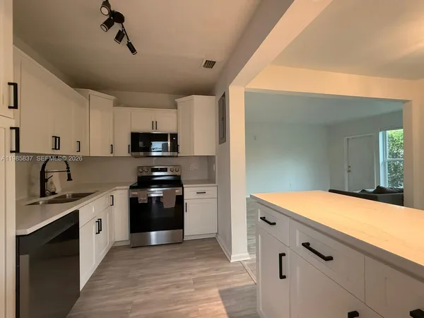 a kitchen with stainless steel appliances granite countertop a sink and a stove top oven