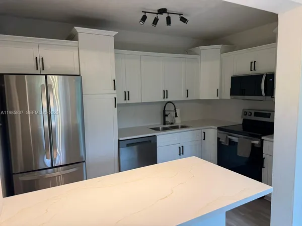 a kitchen with a refrigerator and a sink