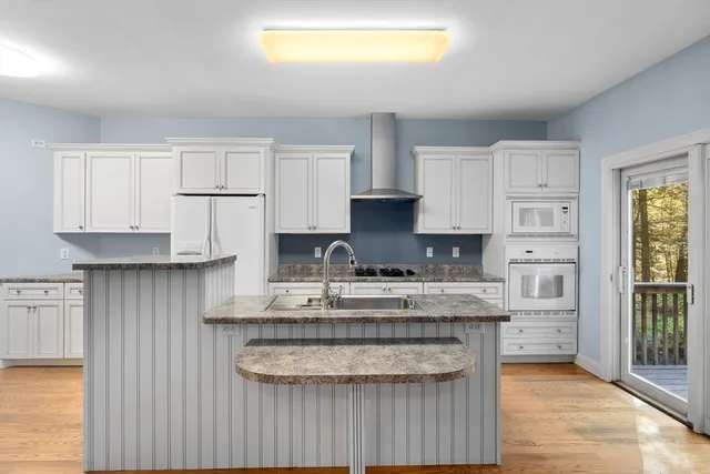 a kitchen with granite countertop white cabinets and a stove