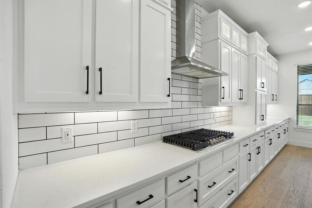 4621 Mount Vista Road Oak Point, TX 75068 - Photo 12 of 40 a kitchen with granite countertop white cabinets and appliances
