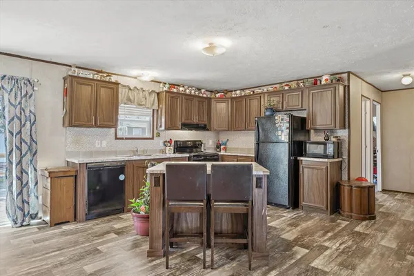 a kitchen with granite countertop a refrigerator stove top oven and sink