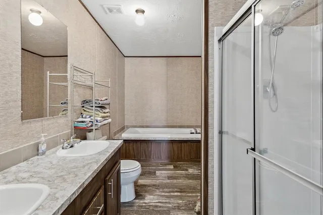 a bathroom with a granite countertop sink a mirror and shower