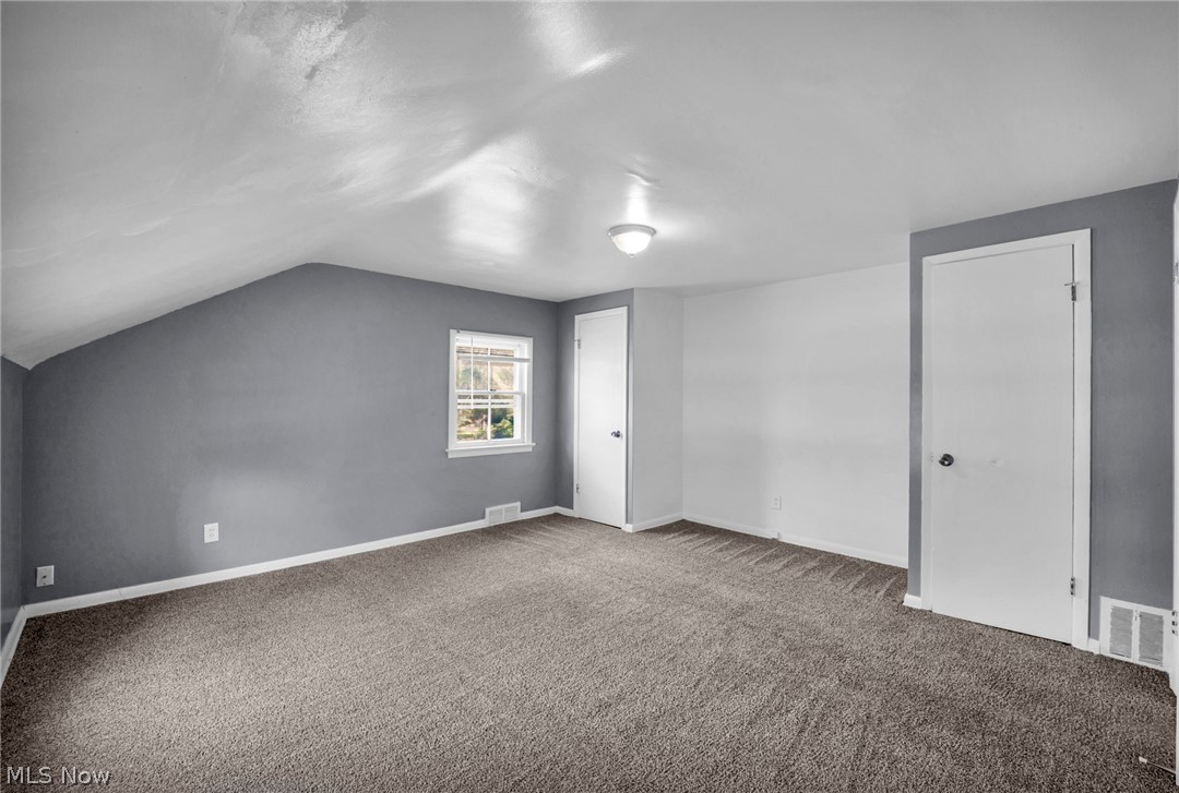 2313 North Taylor Road Cleveland Heights, OH 44112 - Photo 17 of 32 Spacious room featuring sloped ceilings, neutral carpet, and a window providing natural light