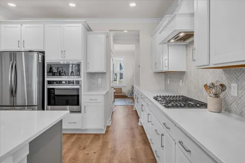 a kitchen with stainless steel appliances granite countertop a stove a refrigerator and a cabinets