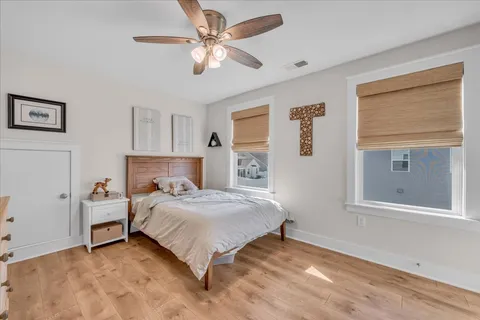 a bedroom with a bed chandelier and a window