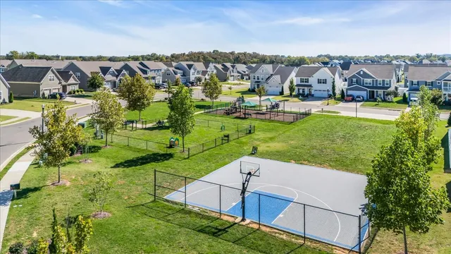 an aerial view of residential houses with outdoor space and trees