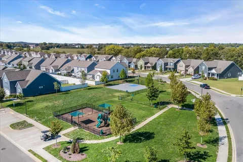 an aerial view of residential houses with outdoor space and trees