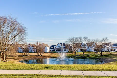 a view of swimming pool with outdoor seating and house in the background