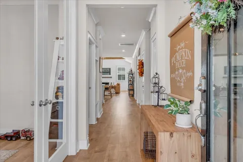 a view of a hallway with wooden floor and a living room