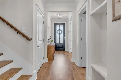 a view of a hallway with wooden floor and staircase