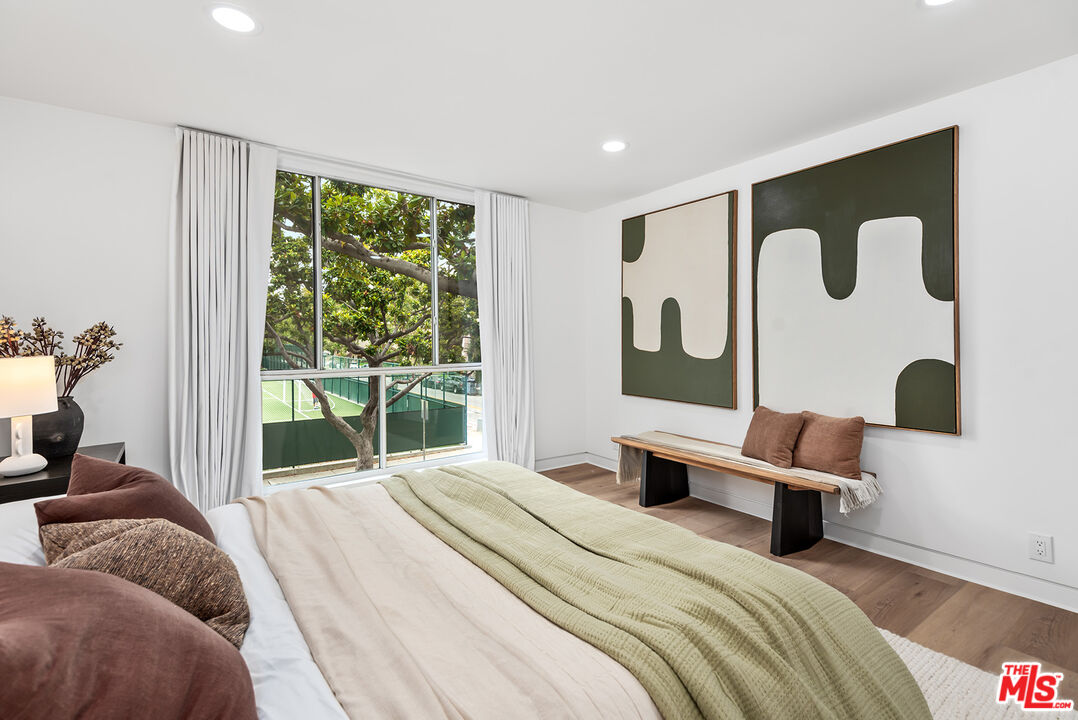 301 South Rexford Drive, Unit 2 Beverly Hills, CA 90212 - Photo 11 of 23 a bedroom with a bed lamp closet and large window