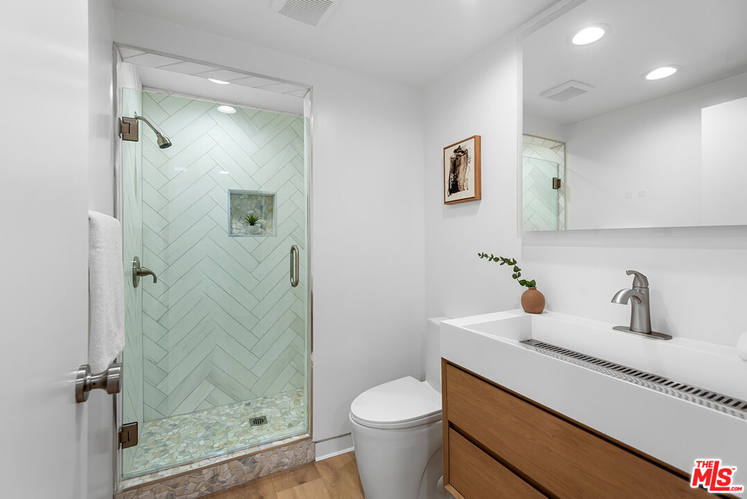 301 South Rexford Drive, Unit 2 Beverly Hills, CA 90212 - Photo 16 of 23 a bathroom with a granite countertop sink a toilet and shower