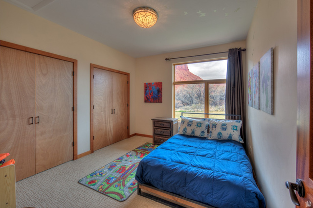 425 Amber Lane Moab, UT 84532 - Photo 17 of 27 Bedroom with two closets and light carpet