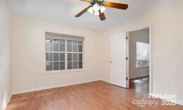 a view of empty room with wooden floor and window