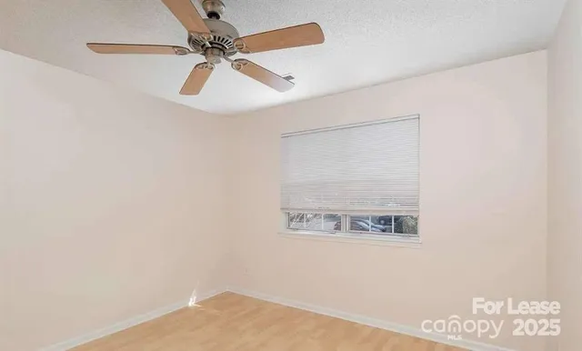 a view of a hallway with a window and a ceiling fan