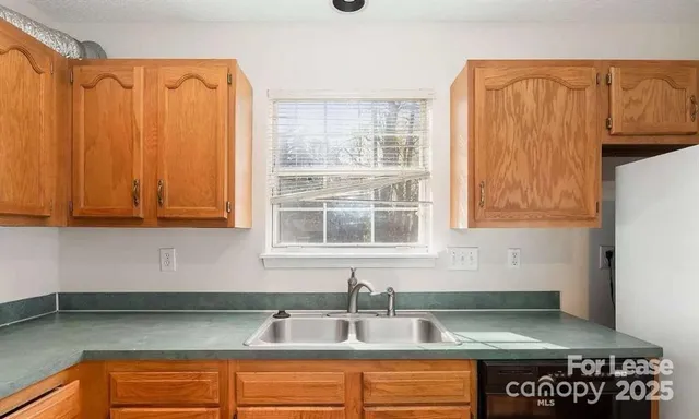 a kitchen with stainless steel appliances granite countertop a sink a microwave cabinets and a counter top space