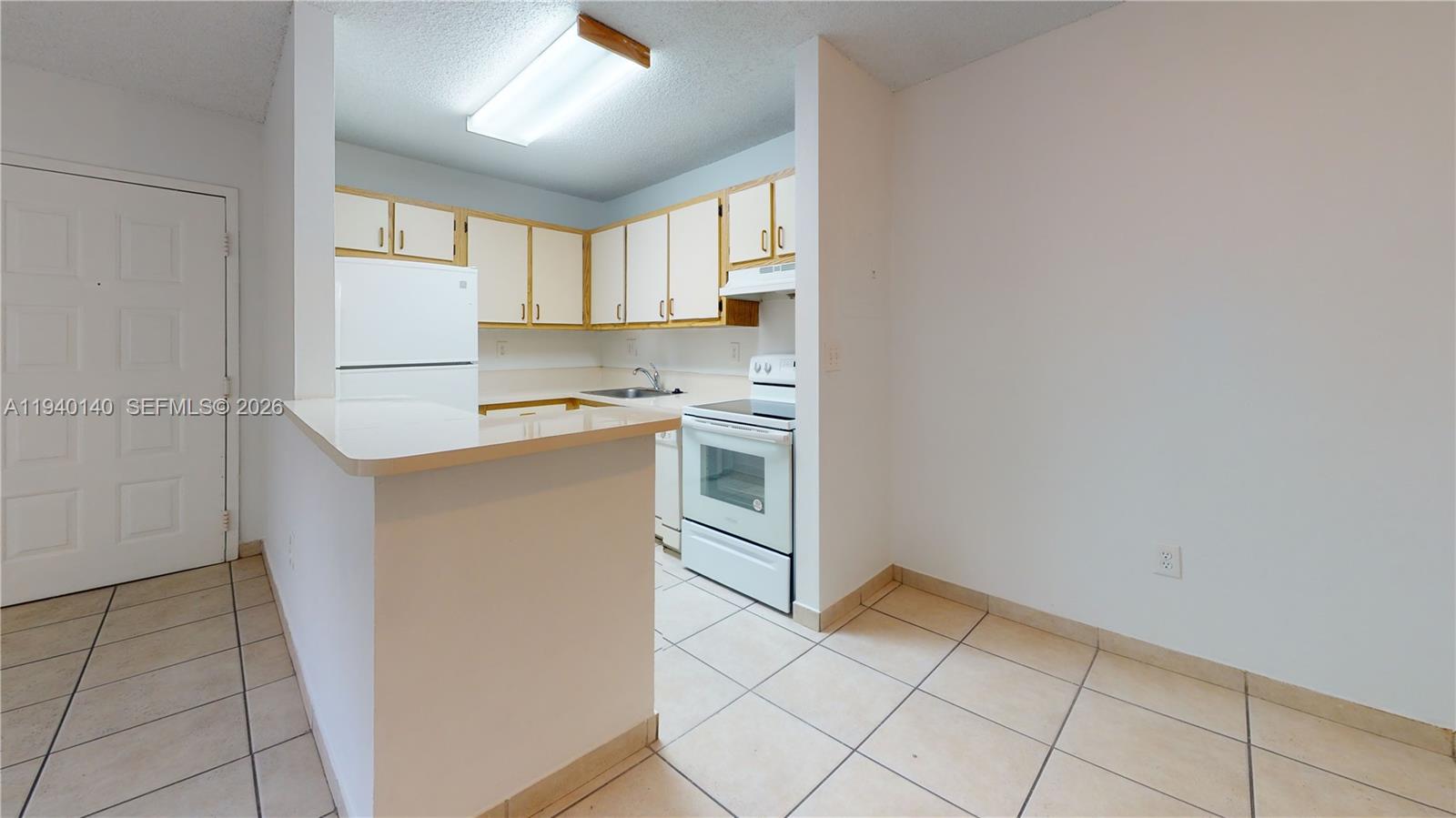 15600 Southwest 80th Street, Unit L202 Miami, FL 33193 - Photo 15 of 18 a kitchen with a stove a sink and a refrigerator