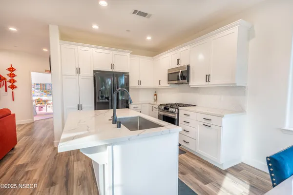 a kitchen with a refrigerator and a stove top oven