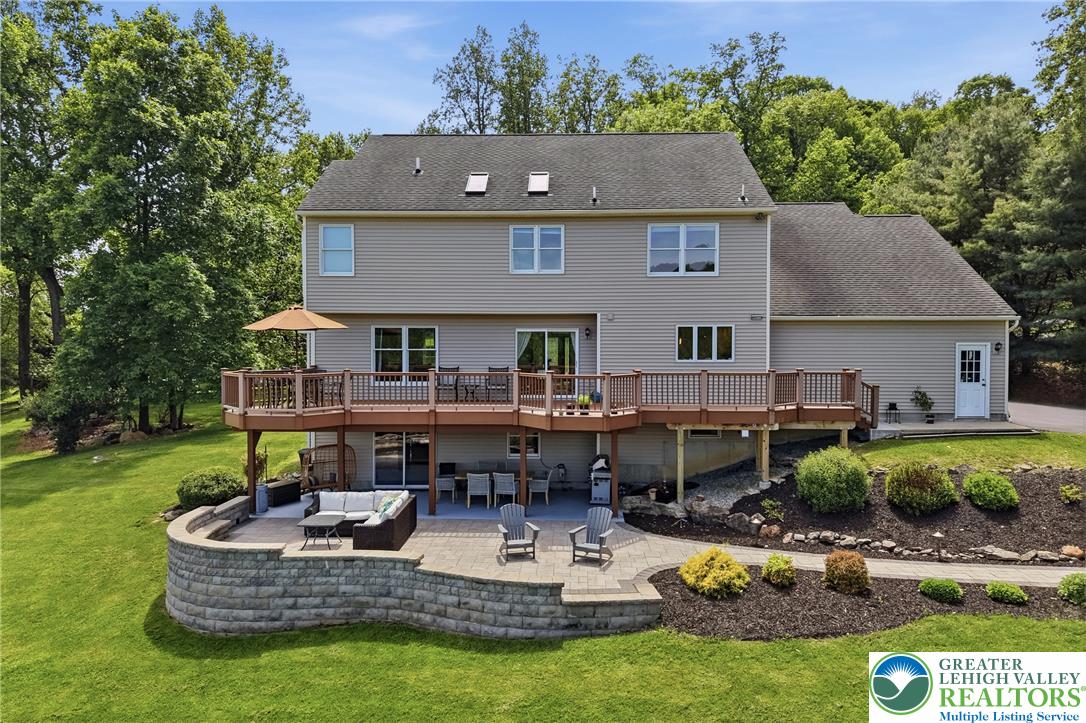 115 West Butternut Road Hellertown, PA 18055 - Photo 70 of 97 A split-level deck and patio provide abundant outdoor living space, overlooking a lush, sloped yard.