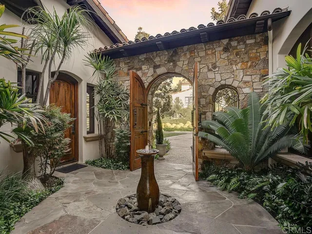 a front view of a house with a garden and mountain view