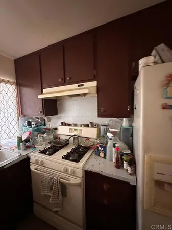 a kitchen with a sink a stove and cabinets