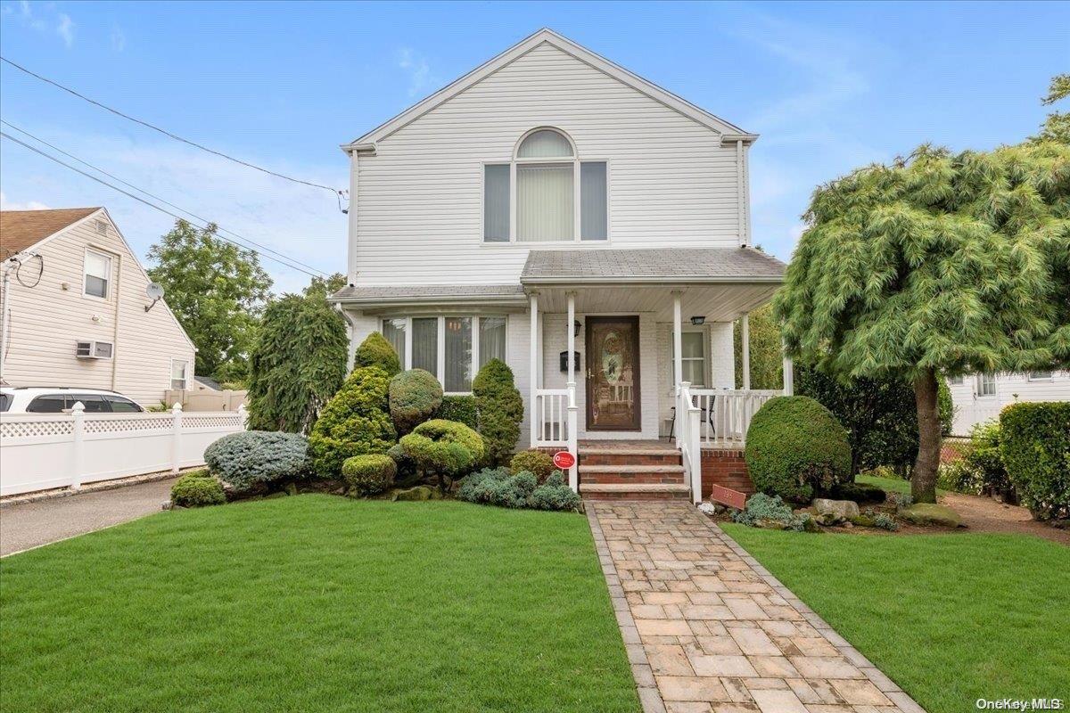 a front view of a house with a garden and plants