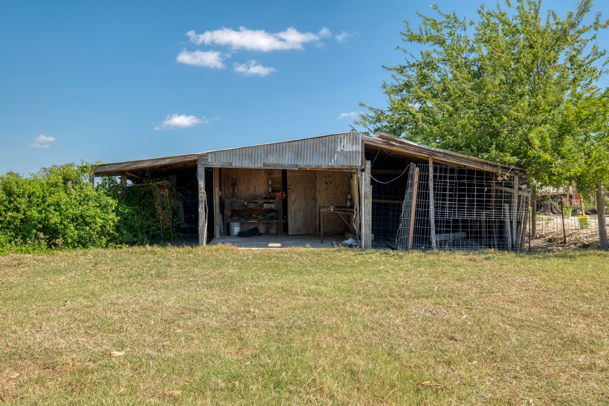 20960 Cameron Road Coupland, TX 78615 - Photo 18 of 21 An open outbuilding sits ready for work and storage on this expansive grassy plot.