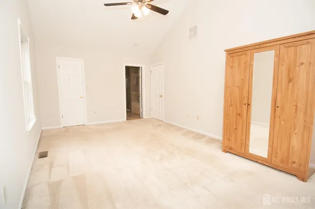 an empty room with windows and fan