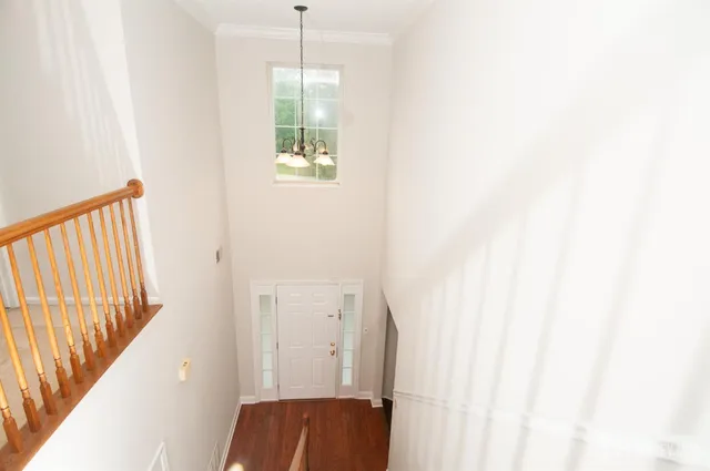 a view of a hallway with wooden floor and stairs