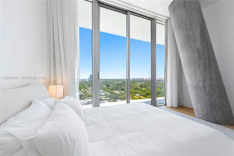 a view of a bedroom with a bed and glass door