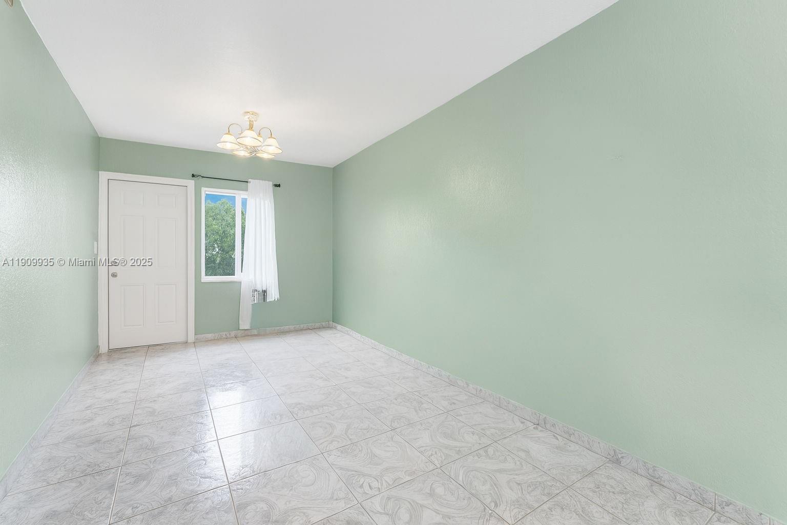 427 Northwest 84th Terrace, Unit 427 Miami, FL 33150 - Photo 14 of 40 en empty room with windows and chandelier fan