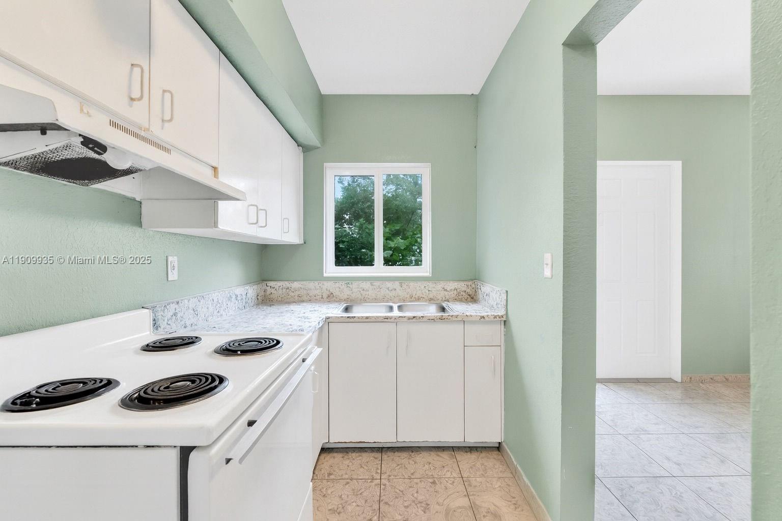 427 Northwest 84th Terrace, Unit 427 Miami, FL 33150 - Photo 21 of 40 a kitchen with a sink stove and cabinets