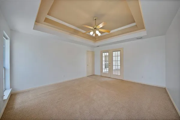 en empty room with windows and ceiling fan