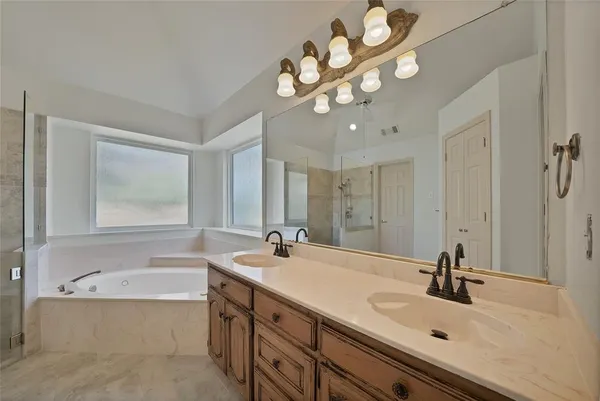 a bathroom with a sink a large mirror and a bathtub