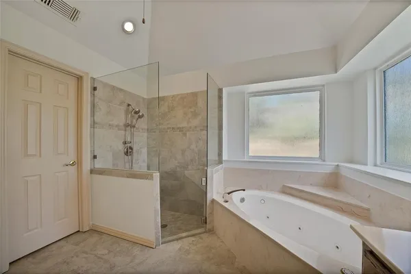 a bathroom with a tub sink and mirror