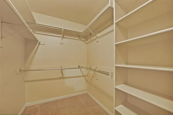 a view of walk in closet with empty racks