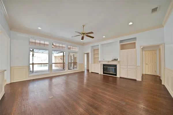 a view of a livingroom with a ceiling fan window and wooden floor