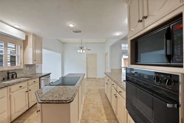 a large kitchen with granite countertop a sink and stove top oven