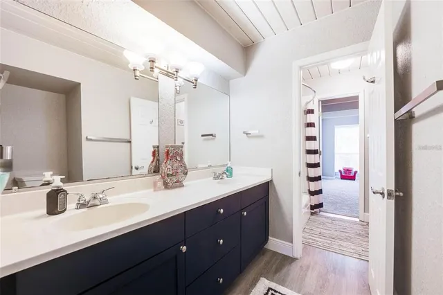 a bathroom with a sink double vanity granite tub shower and a mirror