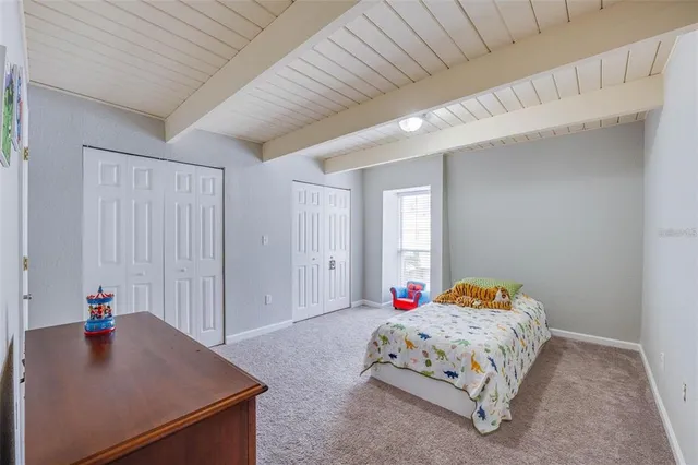 a bedroom with a bed a window and dresser