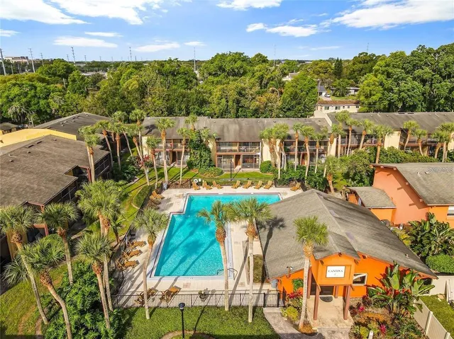 an aerial view of residential houses with outdoor space and trees