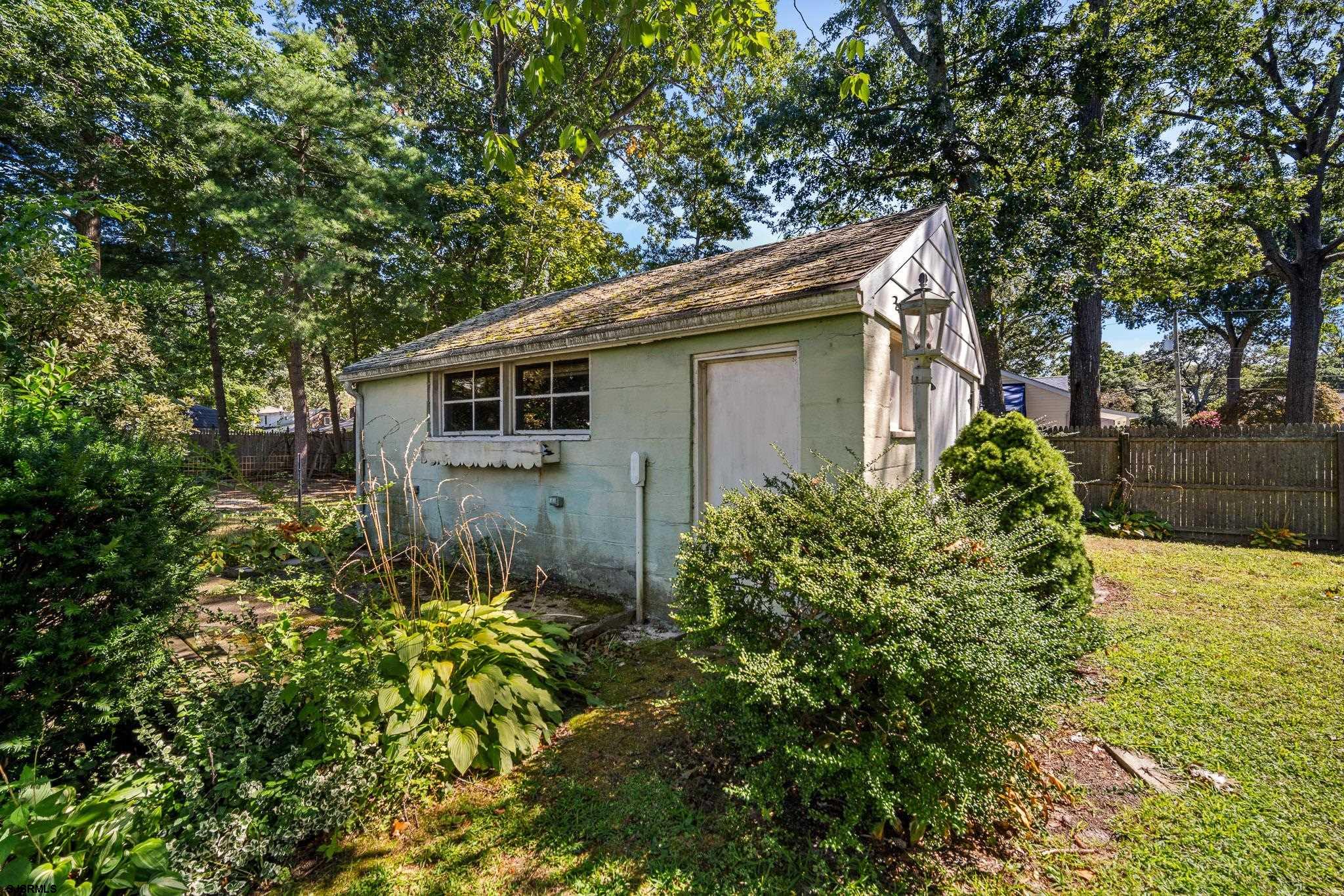 161 Coolidge Avenue Absecon, NJ 08201 - Photo 25 of 26 a yellow house with a flower garden in front of it