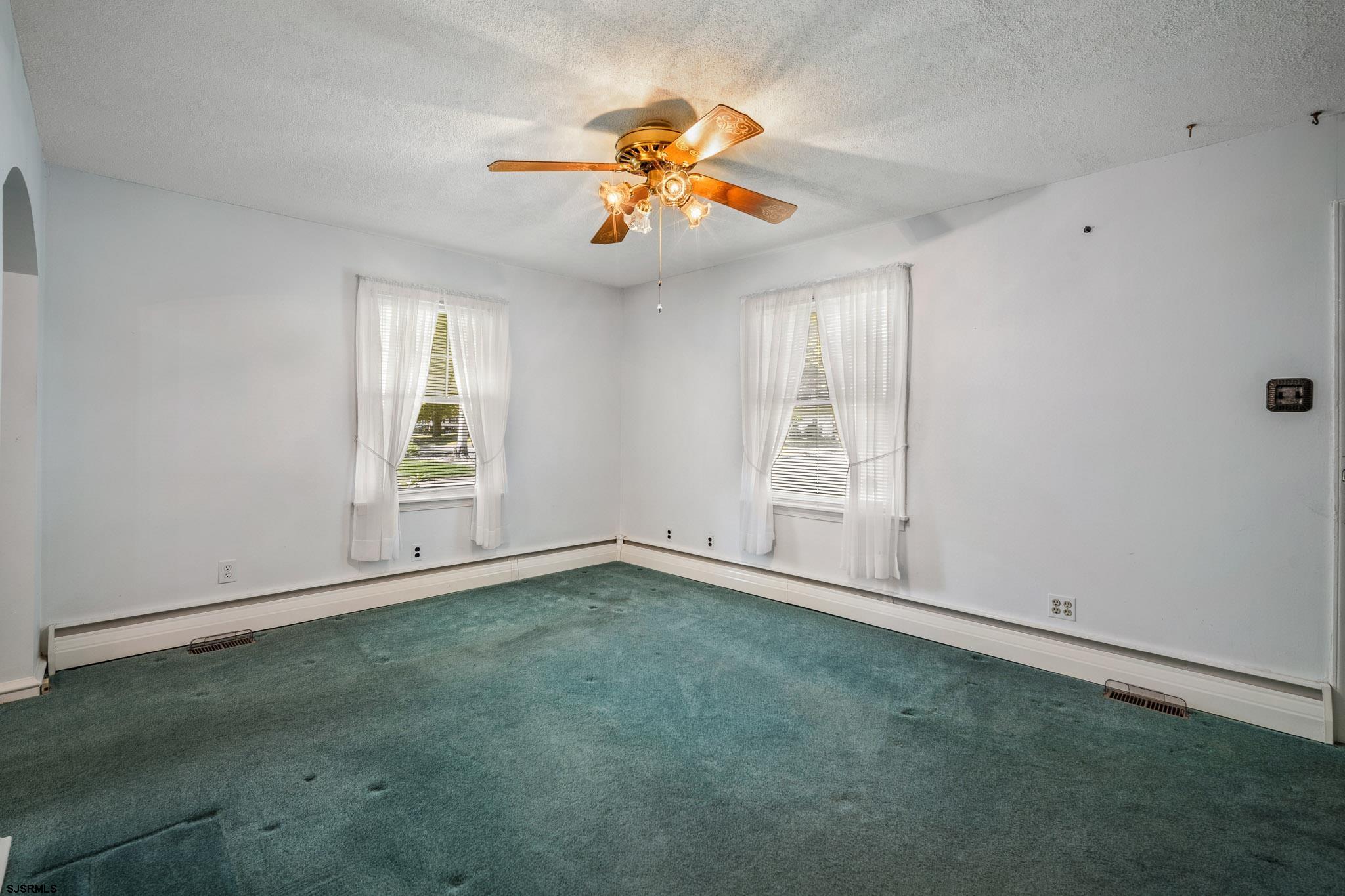 161 Coolidge Avenue Absecon, NJ 08201 - Photo 7 of 26 an empty room with windows and chandelier fan