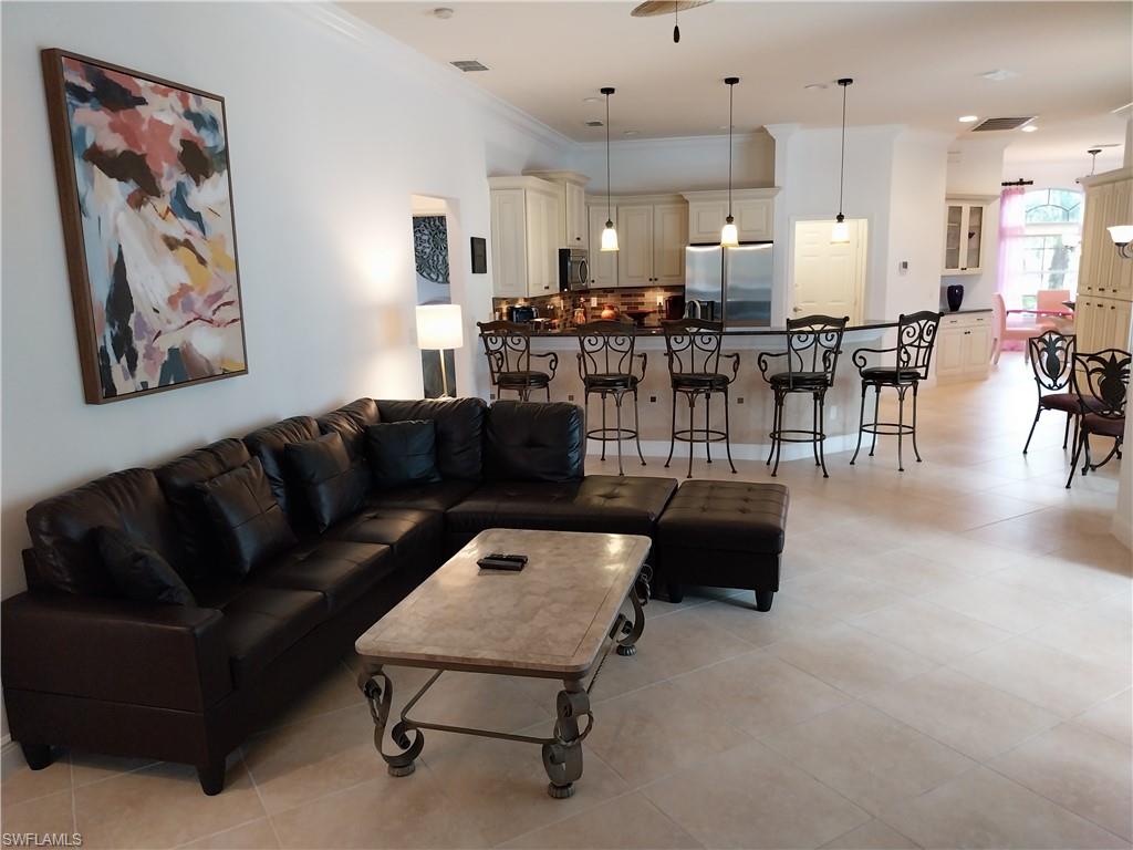 8906 Lely Island Circle Naples, FL 34113 - Photo 12 of 36 a living room with furniture and kitchen view
